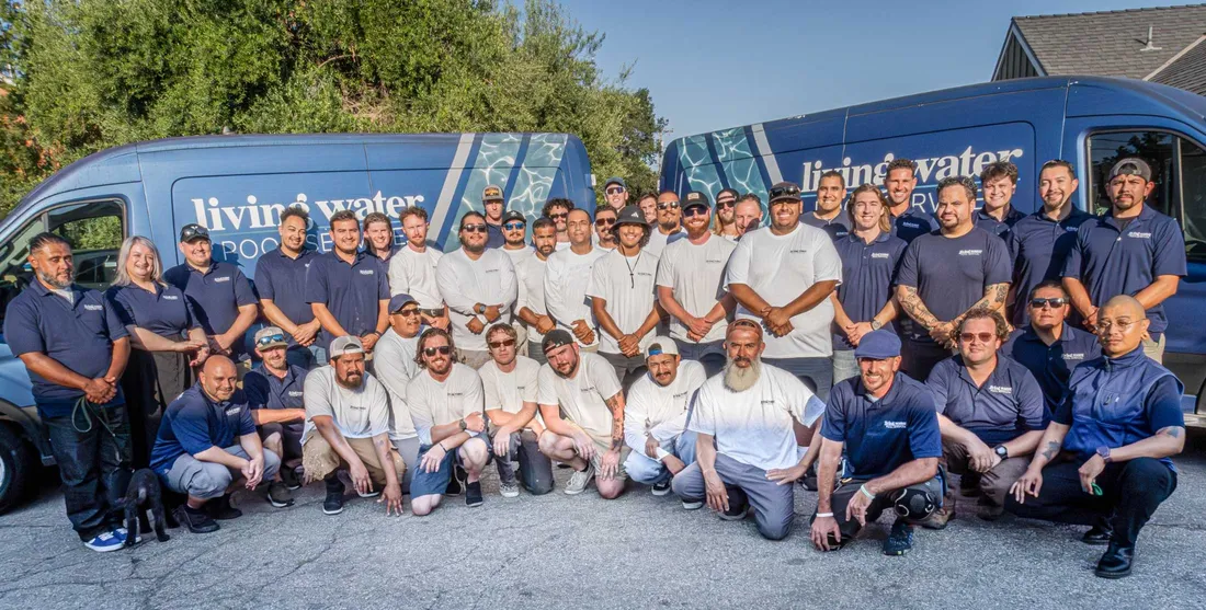 The Living Water Pool Service team in front of their branded service vans